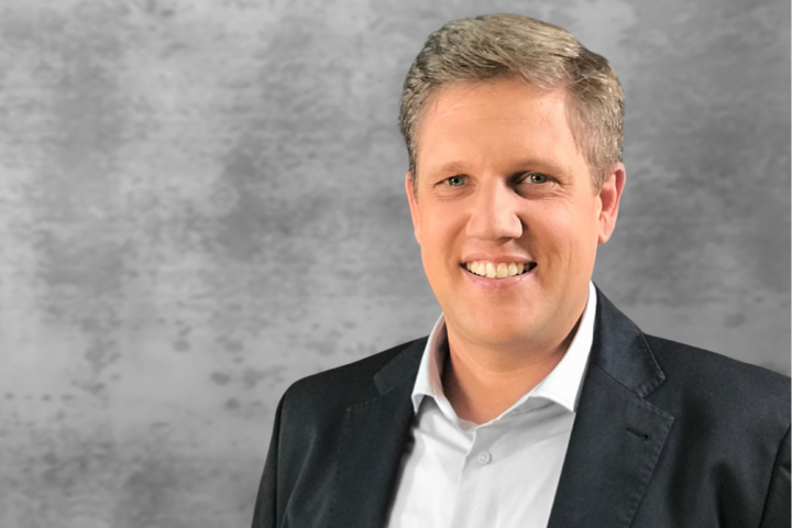 Hellgrauer, leicht marmorierter und unscharfer Hintergrund, darauf Portrait von Robert Schieber